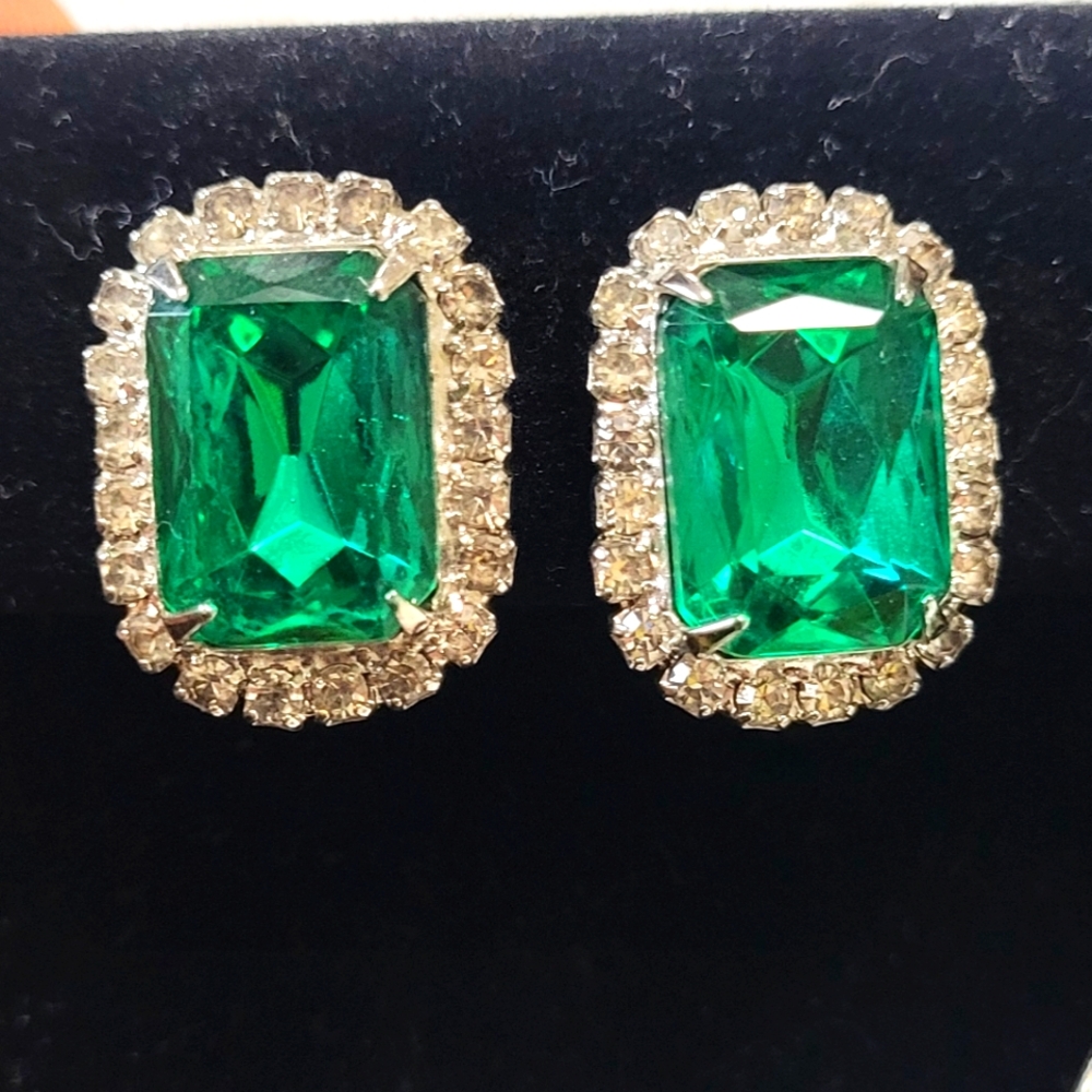 Emerald-cut green stone earrings surrounded by smaler clear stones